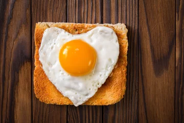 Abwaschbare Fototapete heart shaped cooked egg on a slice of toast © roggozub