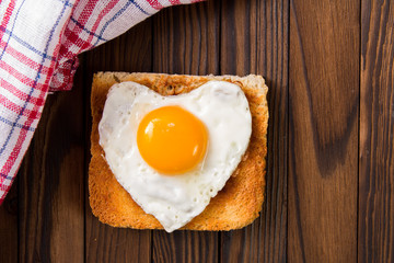 heart shaped cooked egg on a slice of toast