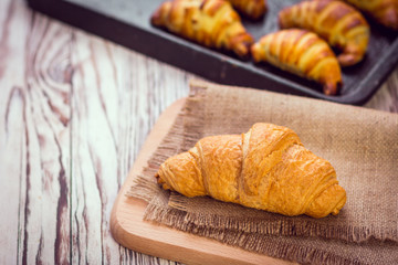 fresh croissants on wooden table