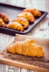 fresh croissants on wooden table