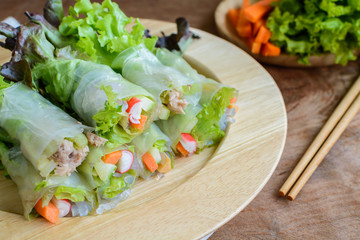 spring rolls with fresh vegetable on wooden table