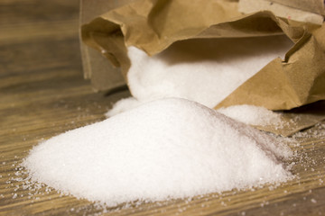 Small table Salt in Kraft box spilled on the wooden background