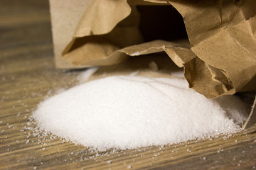 Small table Salt in Kraft box spilled on the wooden background