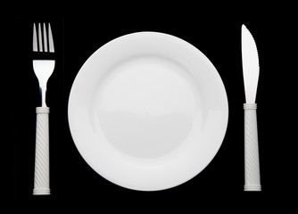 Knife fork and plate on a black background