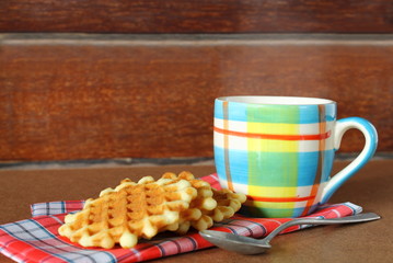 Hot cup of coffee on sack with waffle