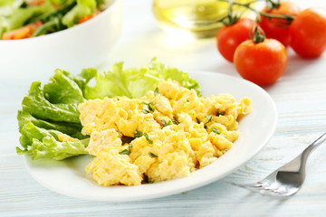 Scrambled eggs with vegetables on a blue wooden table
