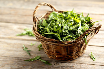 Naklejka premium Fresh arugula leafs on a grey wooden table