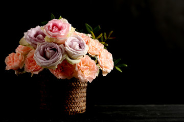Bouquet of beautiful roses on a black wooden table