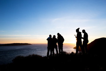 people on bank of sea with sunrise sky