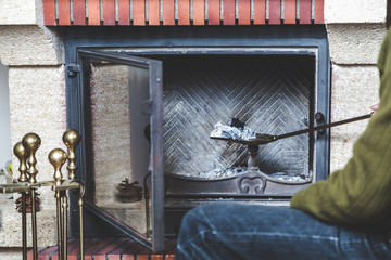 man cleans fireplace with spatula