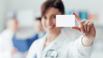 Female doctor holding a business card