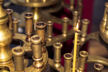 Church burning candle in temple for prayer - soft dramatic