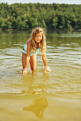 Naklejka premium Mädchen planscht im Wasser im Sommer