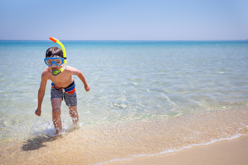 Vacation boy happy snorkeling running having fun in water splashing