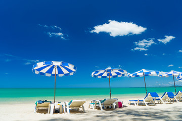  lounge chairs with sun umbrella on a beach