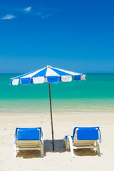  lounge chairs with sun umbrella on a beach