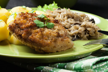 Fried pork schnitzel served with boiled potatoes and fried sauer