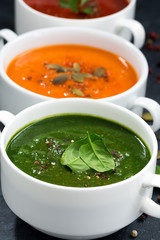 assortment of fresh vegetable cream soup on a black background