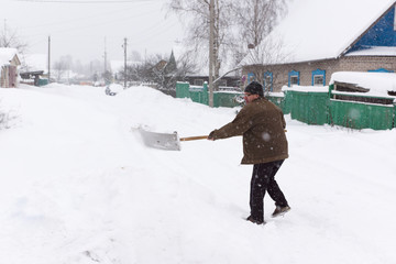 man cleans snow shovel