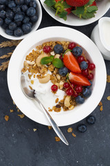 Baked muesli with fresh berries, yogurt and dark background