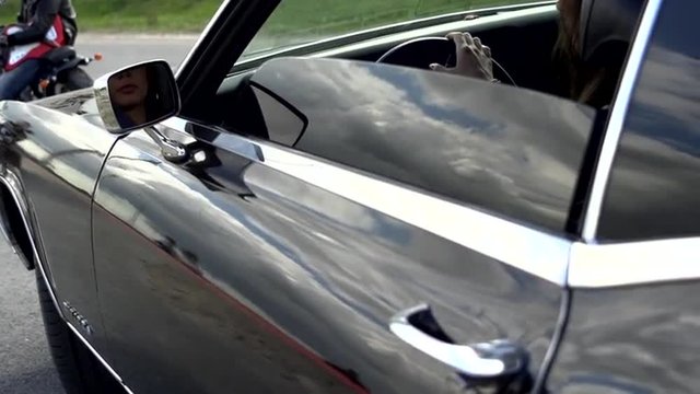 Young girl sitting in the Buick Riviera and closing door in slow motion