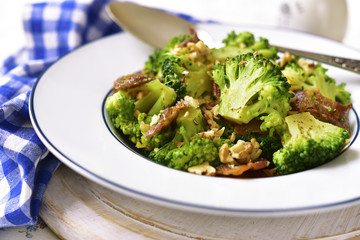 Broccoli with fried bacon and walnuts.