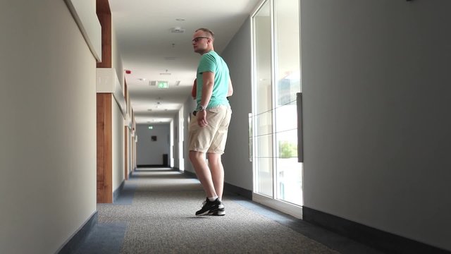 Man looking for his room in hotel with tablet pc.