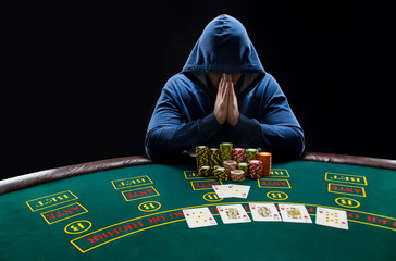 Portrait of a professional poker player sitting at pokers table 
