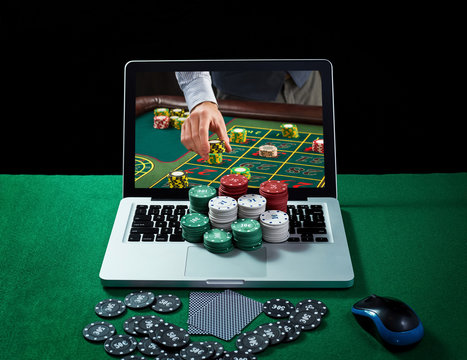 Green table with casino chips and cards on notebook 