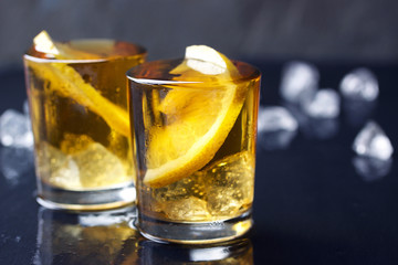 Alcohol cocktail with brandy, whiskey, lemon and ice in small glasses with copy space