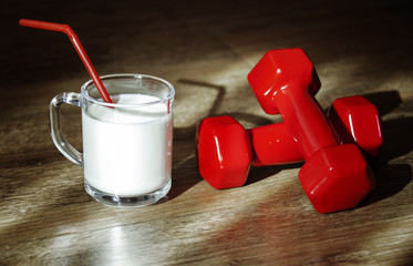 glass of milk and dumbbells for health and fitness
