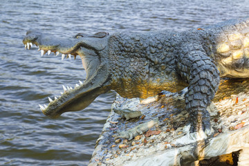 Crocodile statue water waves.