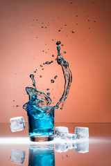 Eiswürfel fallen in ein Glas