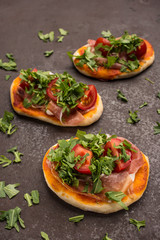 Mini Pizza mit Tomate, Rucola und Schinken