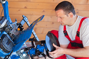 Man installing tilling accessory on agricultural machine