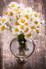 beautiful bouquet of chamomile on vintage wooden table