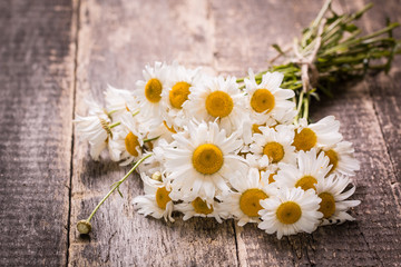 Obraz premium beautiful bouquet of chamomile on vintage wooden table