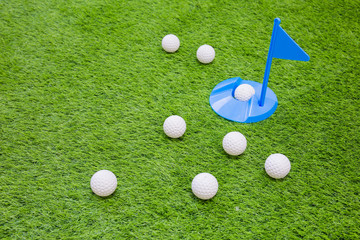 Golf ball on with  one in hole on grass for background