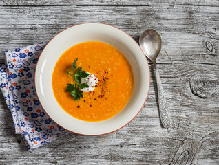 Healthy quinoa carrot soup on rustic light wooden board. Delicious vegetarian food