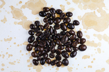 Coffee beans and coffee stains on a white tablecloth..