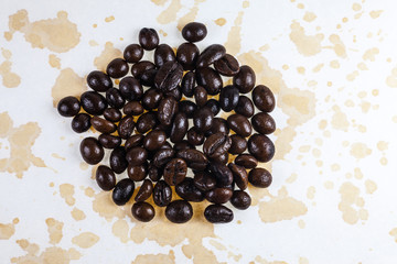 Coffee beans and coffee stains on a white tablecloth..