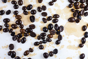 Coffee beans and coffee stains on a white tablecloth..