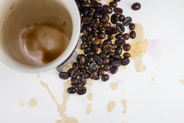 Coffee beans and coffee stains on a white tablecloth..