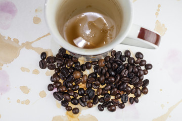 Coffee beans and coffee stains on a white tablecloth..