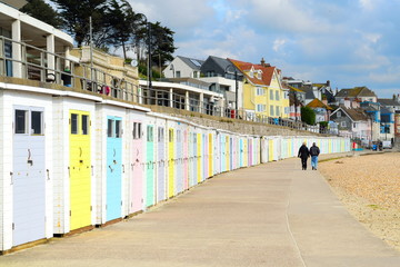 Fototapeta na wymiar Colorful beach huts in coastline town Lyme Regis, England