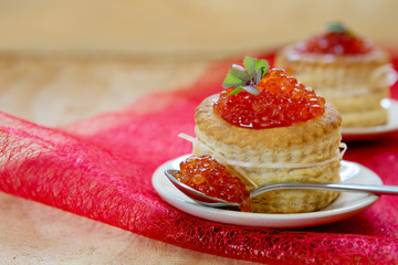 Tartlets with red caviar on plate.