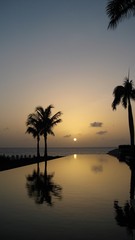 Fototapeta na wymiar a setting sun reflects of a caribbean pool 