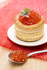 Tartlet with red caviar on plate.