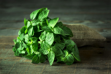 Fresh mint leaves on wooden background © len4foto