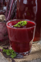 a glass of fresh beetroot juice on old rustic table